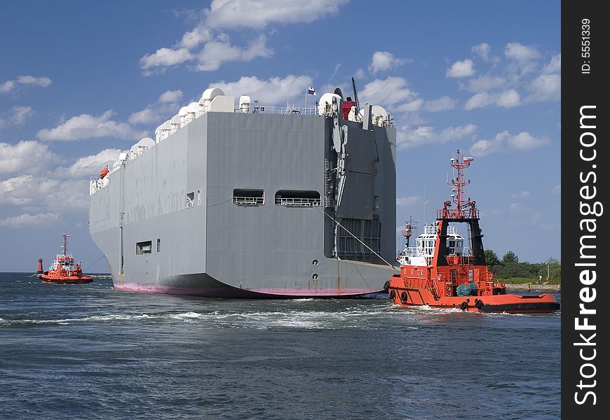 A tugboat assisting huge vessel