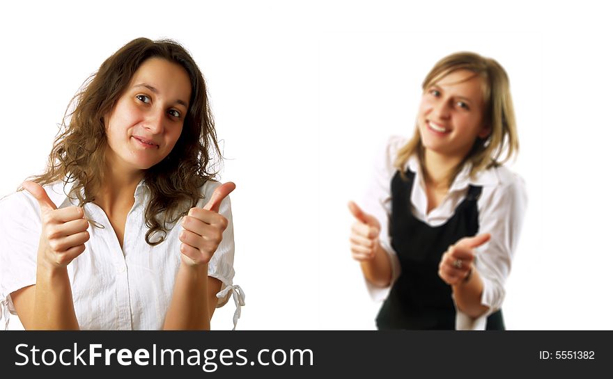 Two young pretty businesswomen colleagues are giving the thumbs up and they are smiling. They are wearing stylish shirts. Two young pretty businesswomen colleagues are giving the thumbs up and they are smiling. They are wearing stylish shirts.
