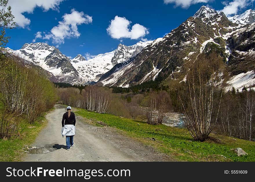 Woman going on the road in mountain landscape. Woman going on the road in mountain landscape