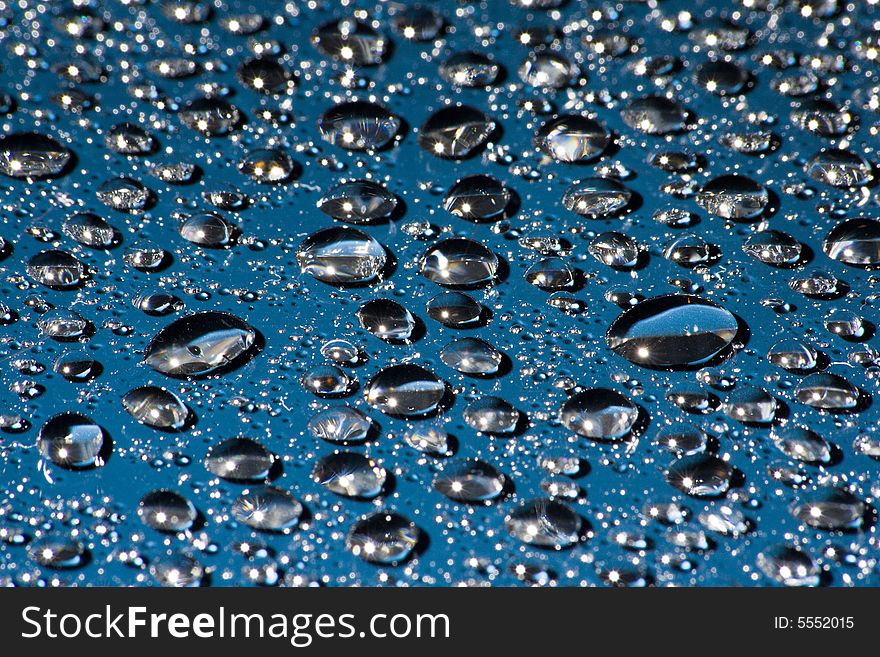 Droplets of water on a blue glass surface. Droplets of water on a blue glass surface