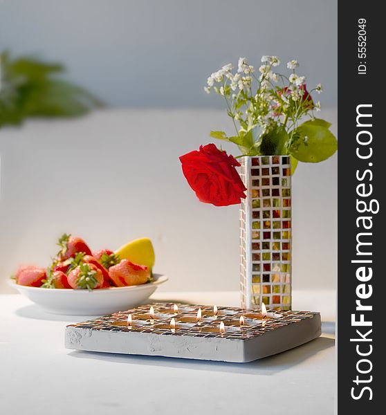 Close up of Mosaic candle holder and Mosaic vase with flowers, white background with space for text, romantic impression. Close up of Mosaic candle holder and Mosaic vase with flowers, white background with space for text, romantic impression