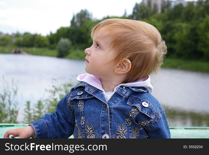 The girl admires a view of beautiful lake. The girl admires a view of beautiful lake