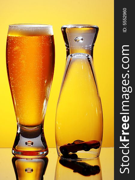 Close-up of glass of beer and upside down glass covering small car. Close-up of glass of beer and upside down glass covering small car