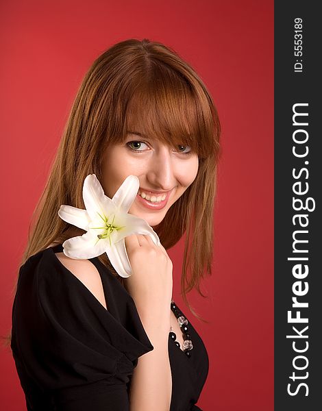 Laughing girl with flower isolated on red background