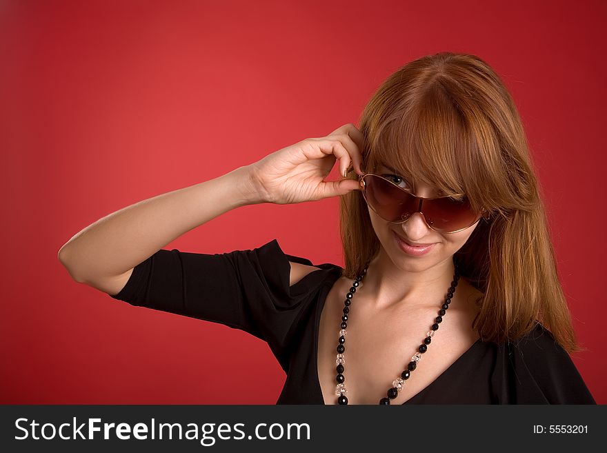 Beautiful girl in eyeglasses isolated on red background