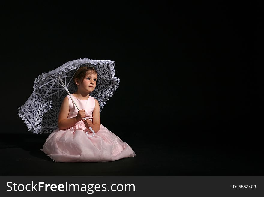 Little girl in a pretty pink dress and lacy parasol