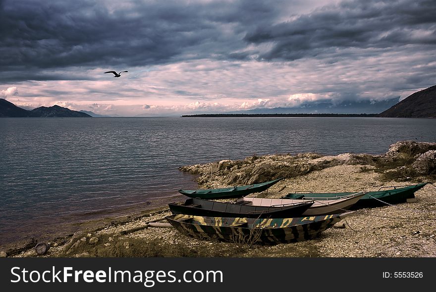 Waterscape with boats, flying bird and dramatic sky. selectively rendered. Waterscape with boats, flying bird and dramatic sky. selectively rendered.