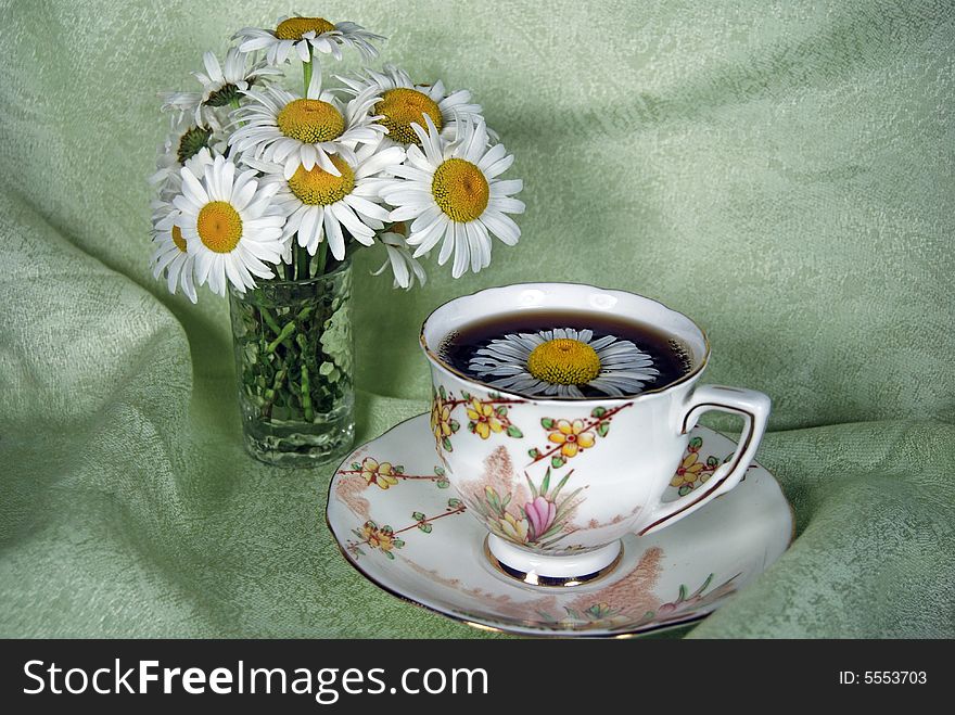 Vintage tea cup and saucer with wild daisies on linen.l. Vintage tea cup and saucer with wild daisies on linen.l