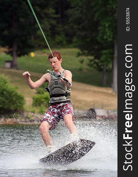 Teenage boy wakeboarding on the lake. Teenage boy wakeboarding on the lake