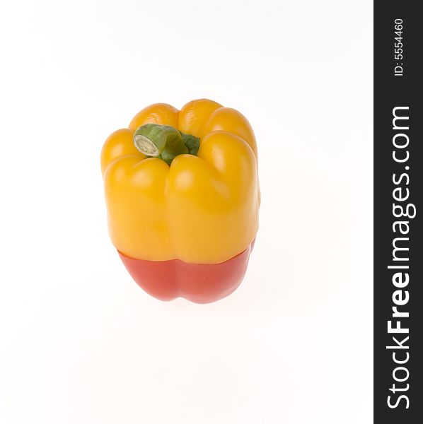 Half of yellow and red peppers combine in one pepper. Half of yellow and red peppers combine in one pepper