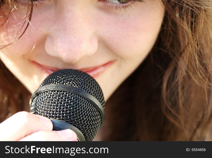 Young beautiful teen girl singing in microphone. Young beautiful teen girl singing in microphone