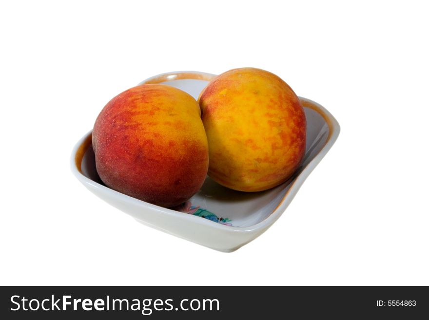 Two peaches in the saucer. isolated on white.