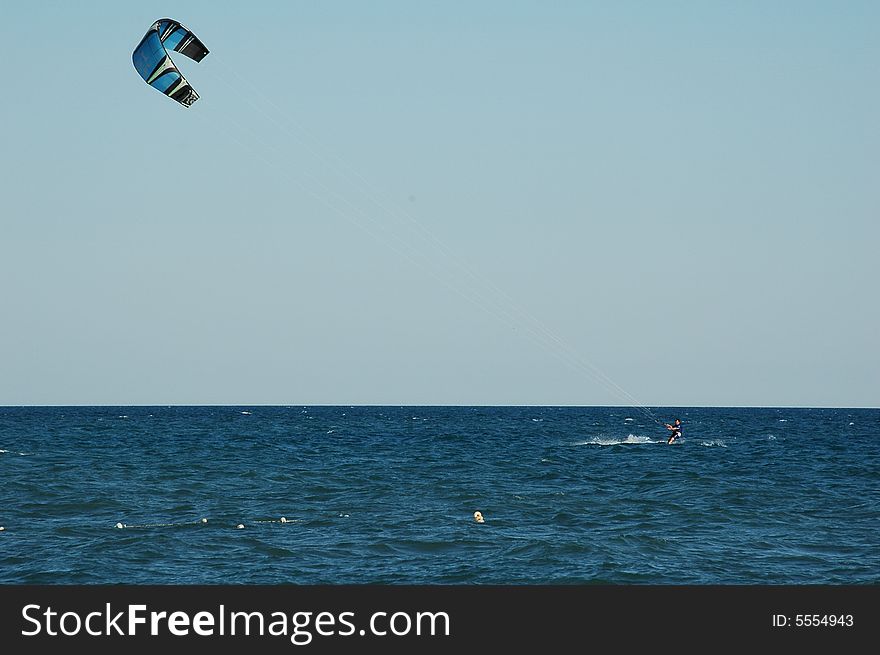 Kitesurfer on the blue mediterranean with a blue sky. Kitesurfer on the blue mediterranean with a blue sky