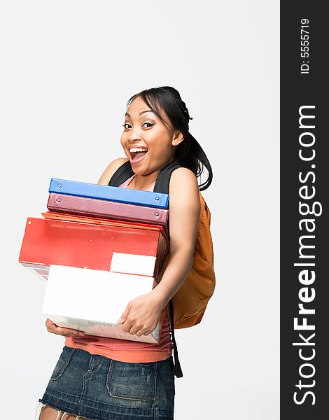 Happy female student wearing a backpack carries notebooks and papers. Vertically framed photograph. Happy female student wearing a backpack carries notebooks and papers. Vertically framed photograph.