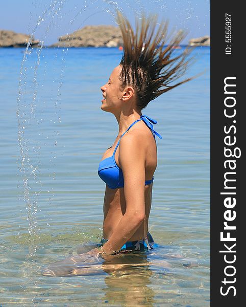 Joung girl throwing hair back in water. Joung girl throwing hair back in water