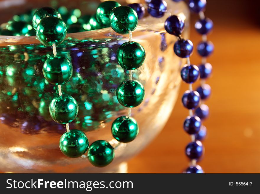 Necklace with green and blue pearls in a bowl