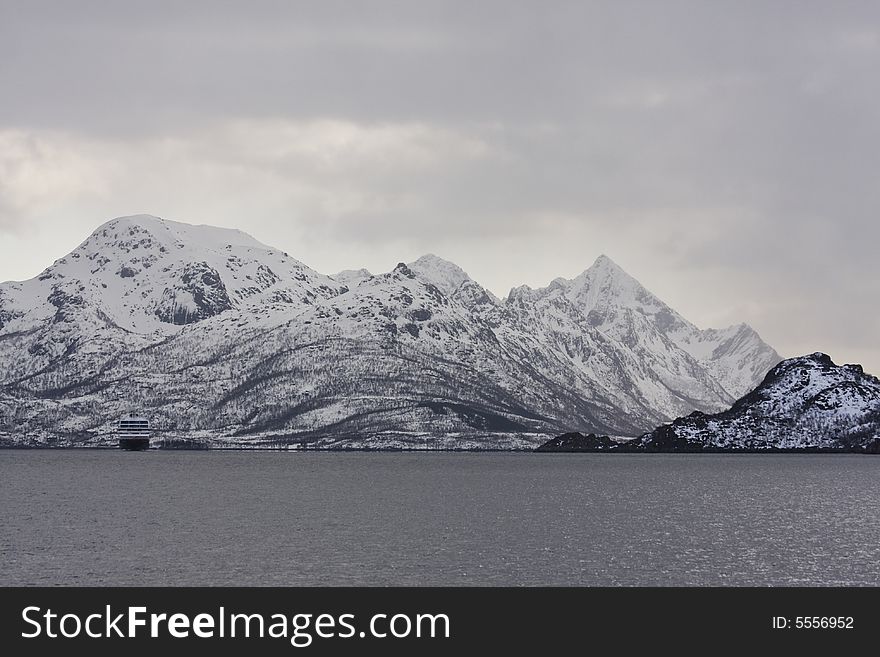 Ship and snow-covered mountains at the Arctic ocean. Ship and snow-covered mountains at the Arctic ocean