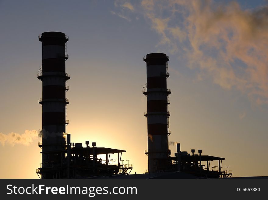 Chimneys of Industrial complex plant at sunset