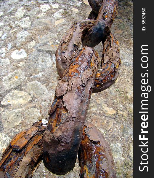 Rusty iron chain with ground as background