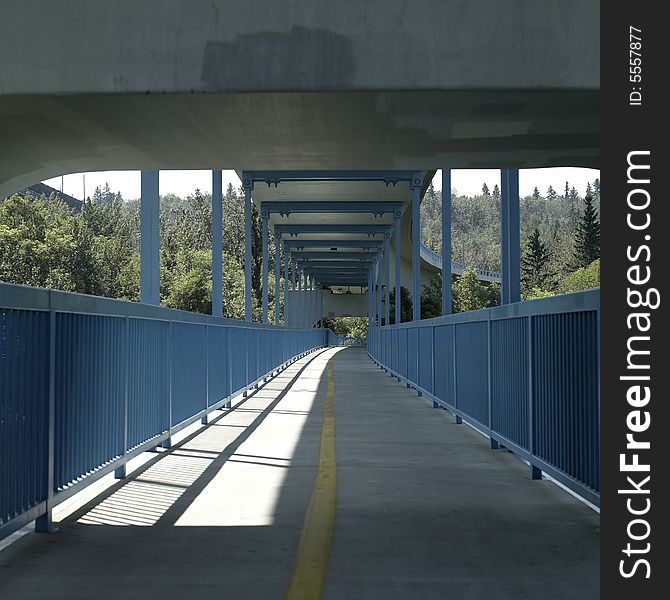 A blue covered pedestrian and cyclist bridge. A blue covered pedestrian and cyclist bridge