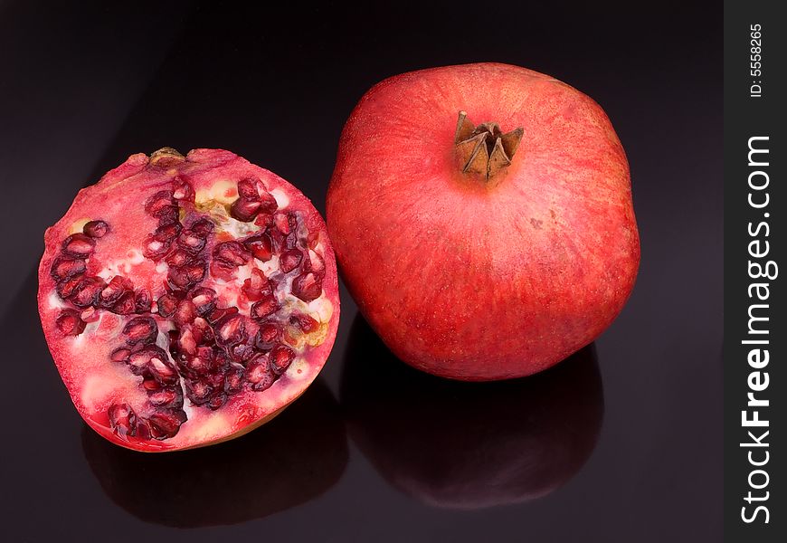 Pomegranates with one cut open to show the seeds.