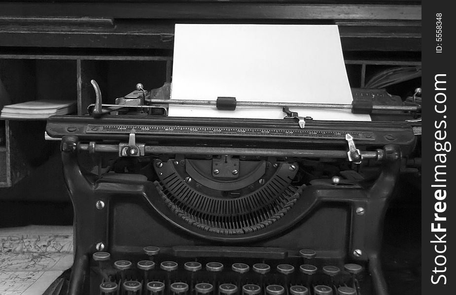 Black and white image of old typewriter and desk