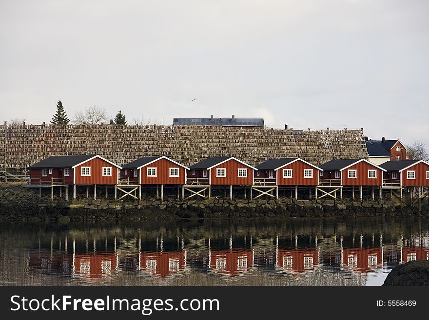 Red houses on stilts at the sea, with stick fish