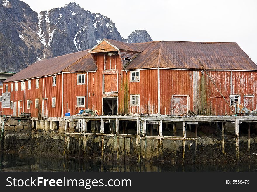 Red house on stilts at the sea