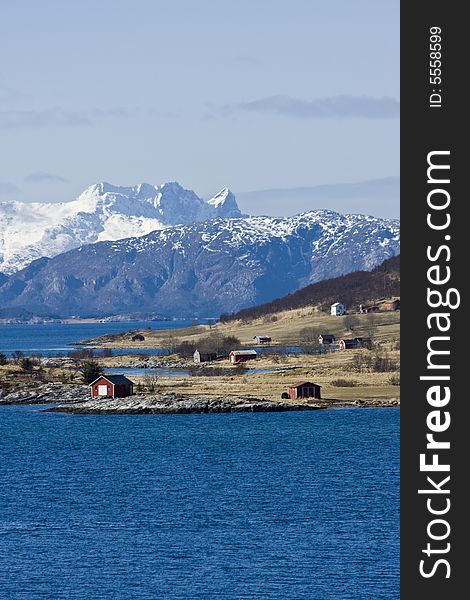 Snow-covered mountains at the Arctic ocean, village. Snow-covered mountains at the Arctic ocean, village