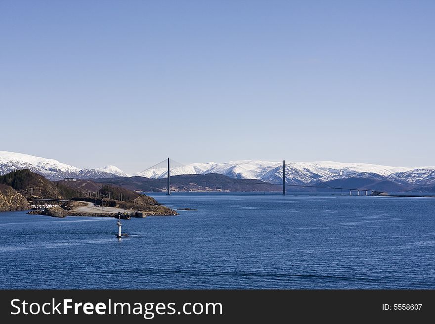 Snow-covered mountains with bridge in the fjord. Snow-covered mountains with bridge in the fjord