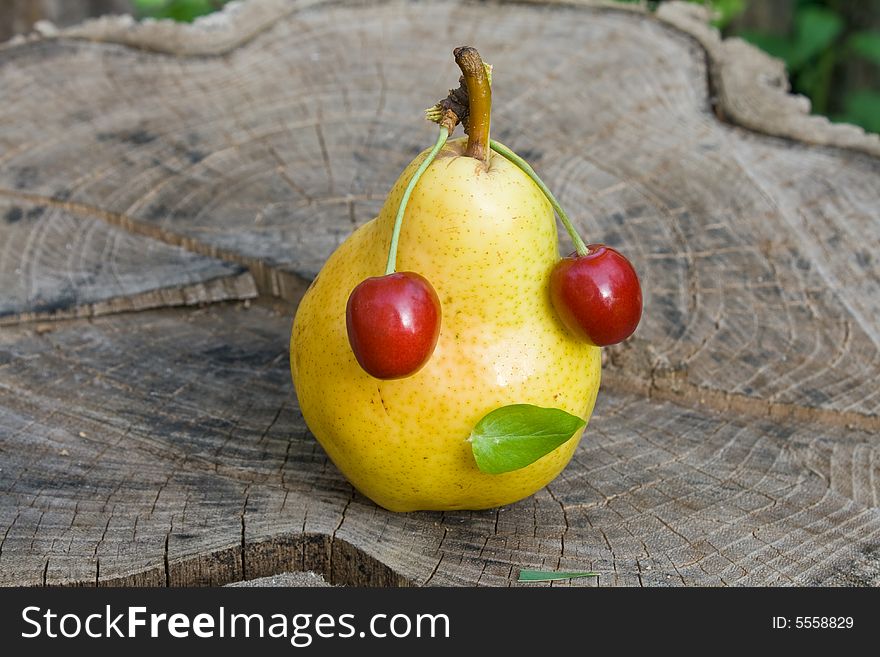 Pear with cherry on wood plate. Pear with cherry on wood plate