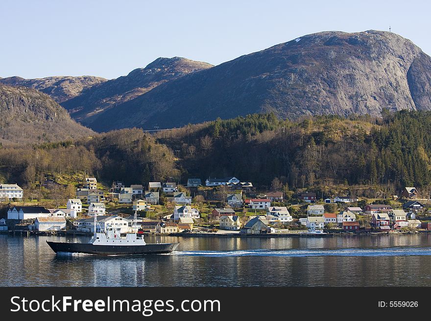 Coastal village in Norway, ferry in the foreground