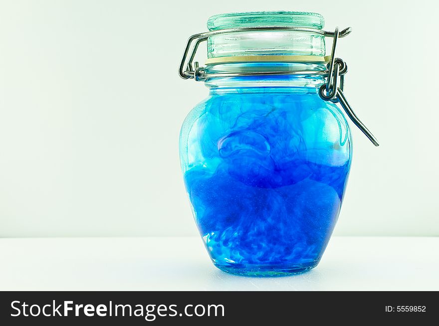 An antique jar full of water and blue colour with the lid closed. An antique jar full of water and blue colour with the lid closed.