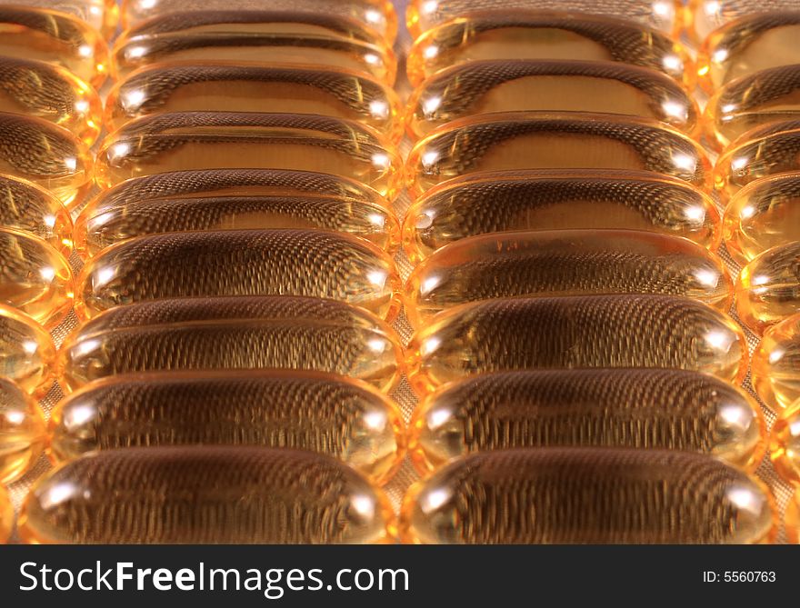 Close up detail of rows of golden vitamin E gel caps. Close up detail of rows of golden vitamin E gel caps