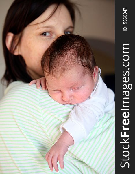 A new born baby  lying over her mother's shoulder. A new born baby  lying over her mother's shoulder