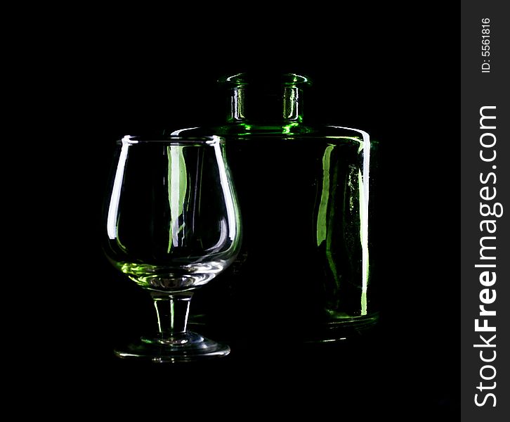 An image of glass with bottle on black. An image of glass with bottle on black