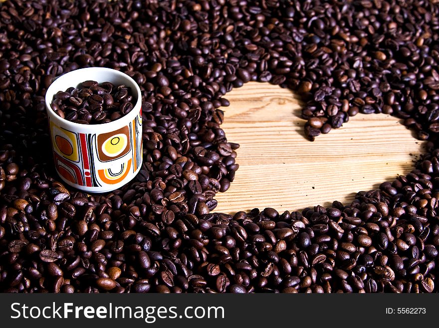 A cup of coffee on coffee beans with heart