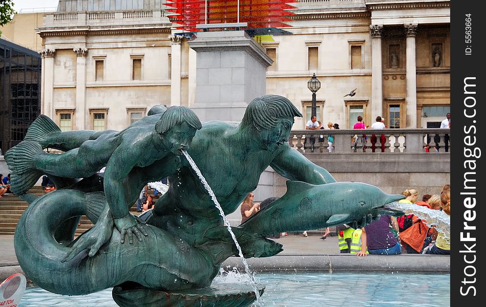 Bronze fountain with a nude young man, a boy and dolphins in Trafalgar Square, London