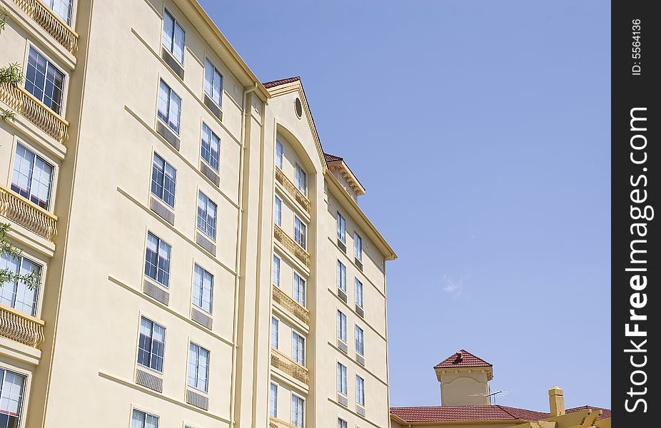A yellow and gold stucco hotel against a blue sky