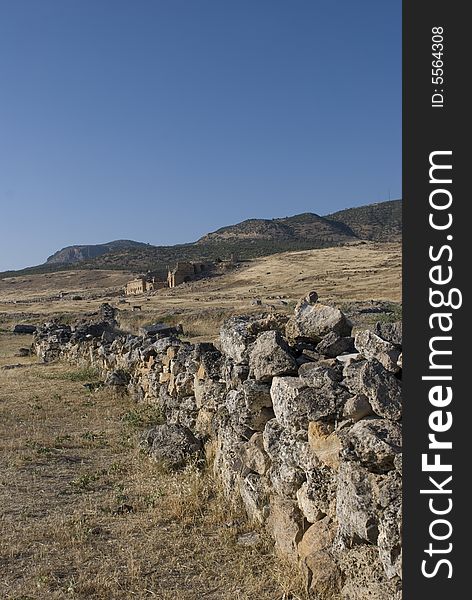 A short stone wall leading to the castle in the ancient city of heirapolis