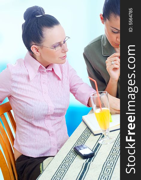 Two young businesswomen working on coffee break, outdoors