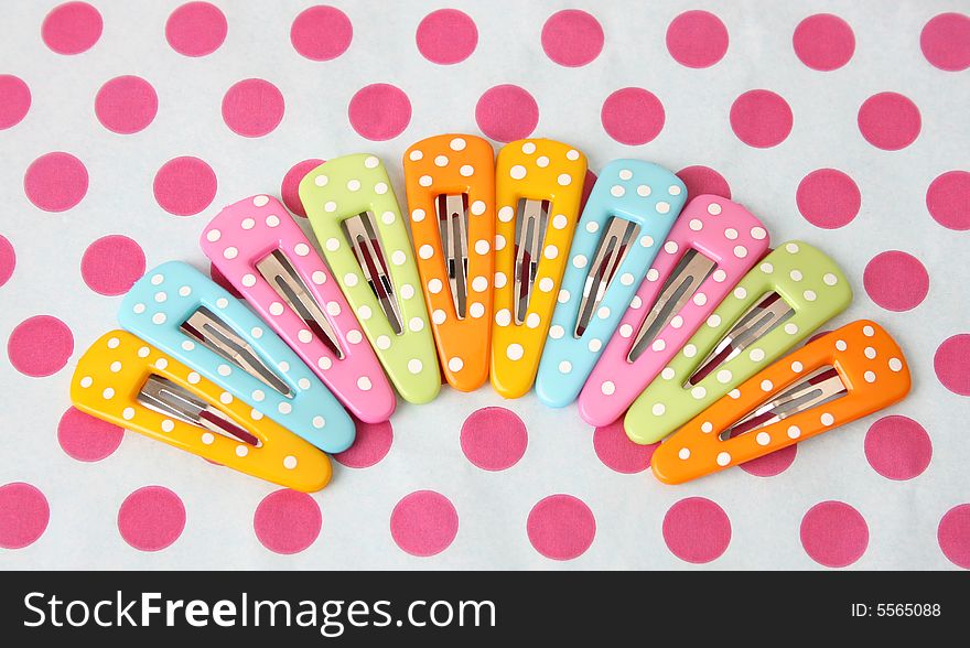 Brightly colored polka dot hair accessories on a polka dot background