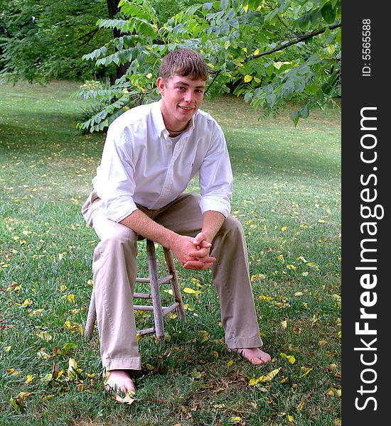Young man in white shirt and tan pants in outdoor location. Young man in white shirt and tan pants in outdoor location