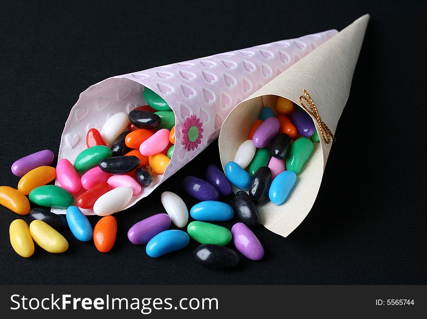 Cones filled with colorful jelly beans on a black background. Cones filled with colorful jelly beans on a black background