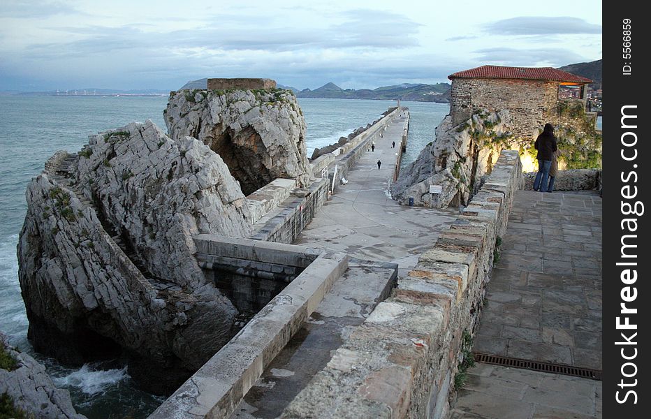 Promenade along the walls and on a mole with a rocks, in Cantabrigian sea