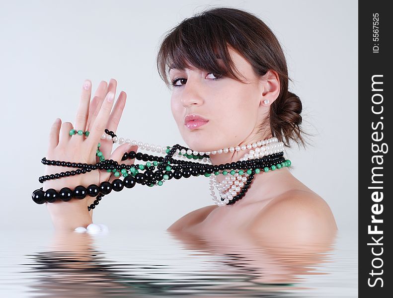 Young beautiful girl with a great number beads on a neck, which winds them on a hand. Young beautiful girl with a great number beads on a neck, which winds them on a hand