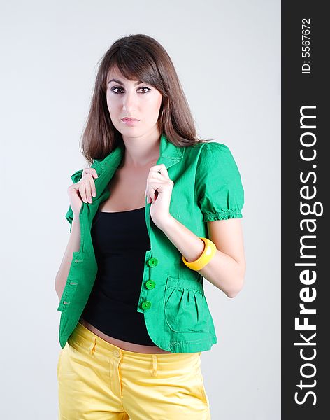 Beautiful girl in a green blouse and yellow shorts on a white background. Beautiful girl in a green blouse and yellow shorts on a white background