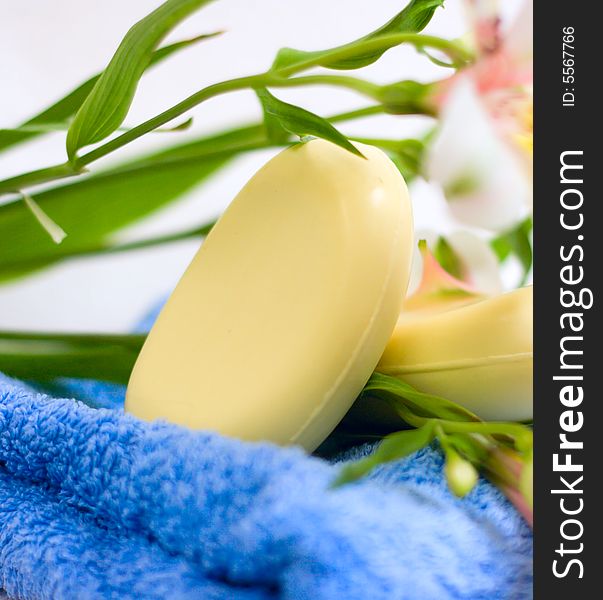 Soap and flower on blue fabric background for your design