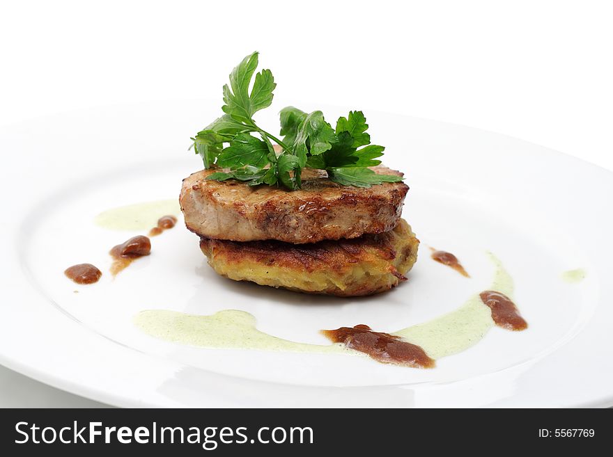 Pork with sauce on a plate isolated over white