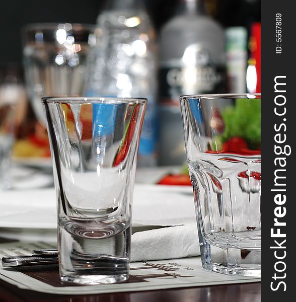 Empty Glasses on Banquet Table with Glare in Bottle Background